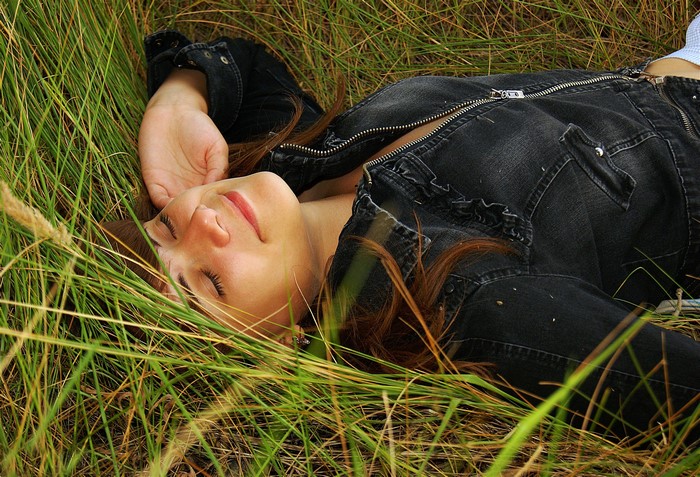 Young woman sleeping in grass