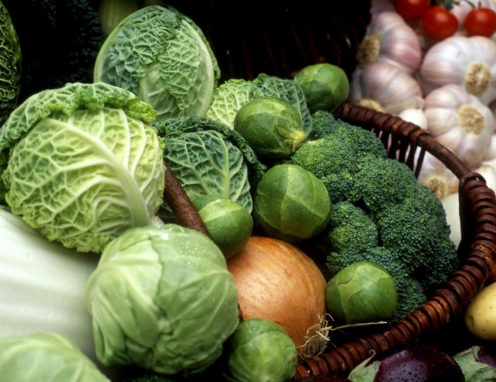 Vegetables including cabbage, onion, and broccoli in a basket
