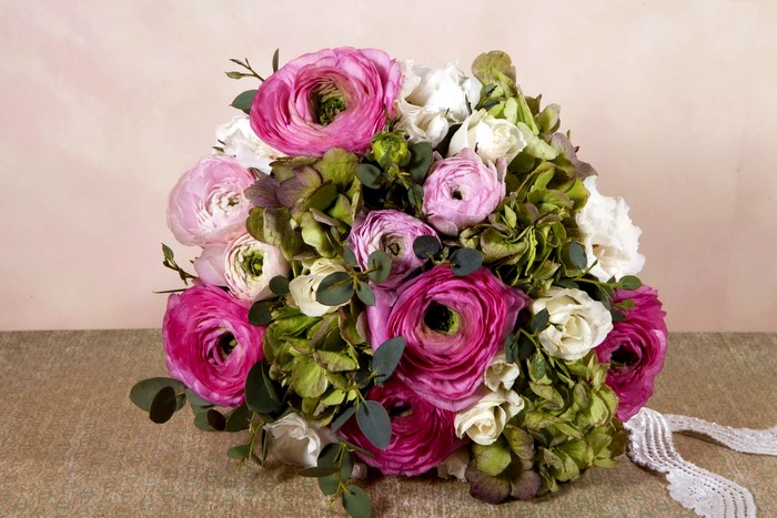 Bouquet of pink and white ranunculus flowers with green hydrangeas
