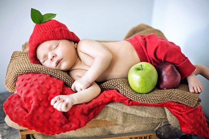 Baby in Apple Hat Sleeping with Apples