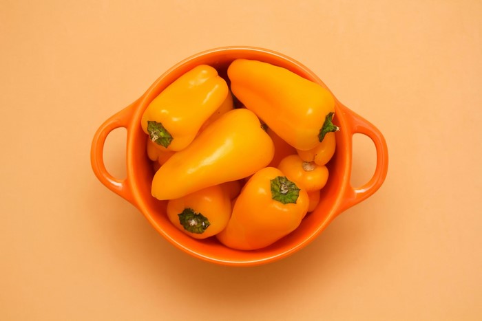 Yellow bell peppers in an orange bowl