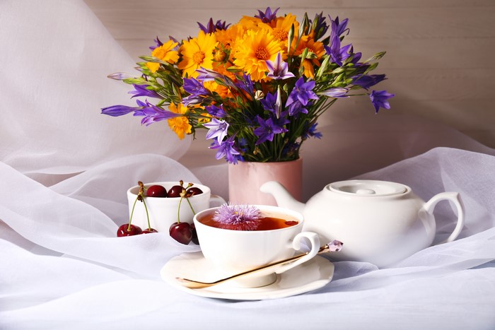 Still-life with tea, cherries, and flowers