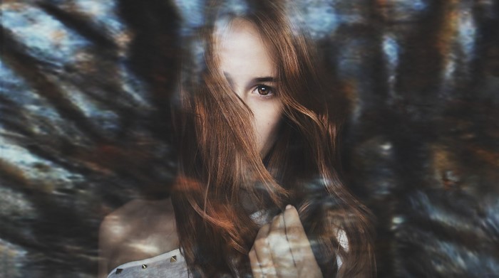 Woman with brown hair looking through her hair
