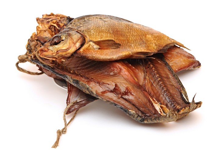 Smoked fish tied with rope on white background