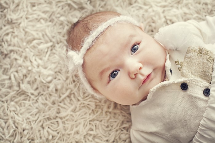 Infant with blue eyes wearing a white headband