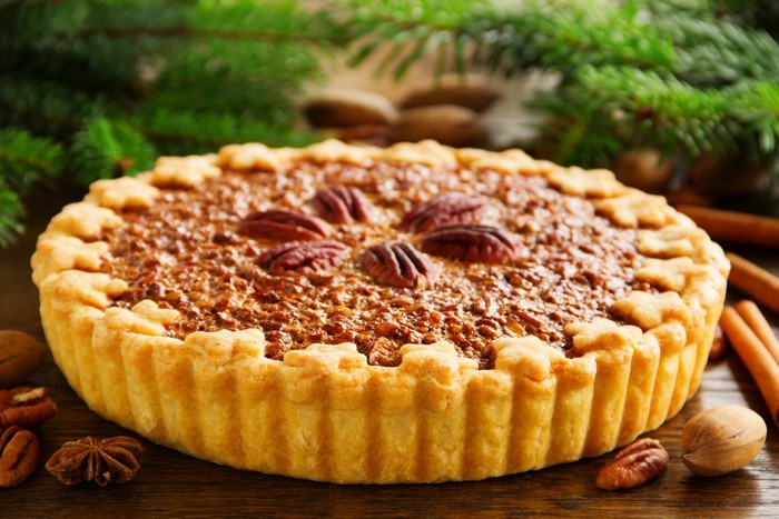 Pecan pie with pecans and cinnamon sticks
