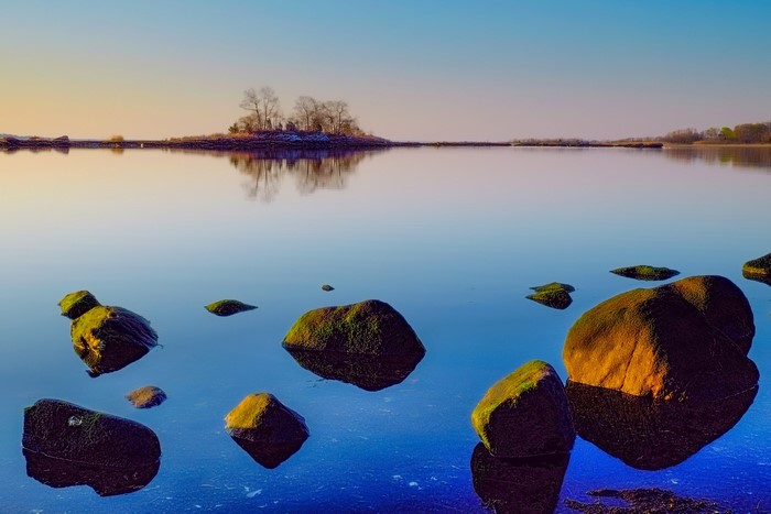 Rocks in a calm lake at sunset