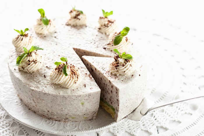 White cake with cream swirls and mint