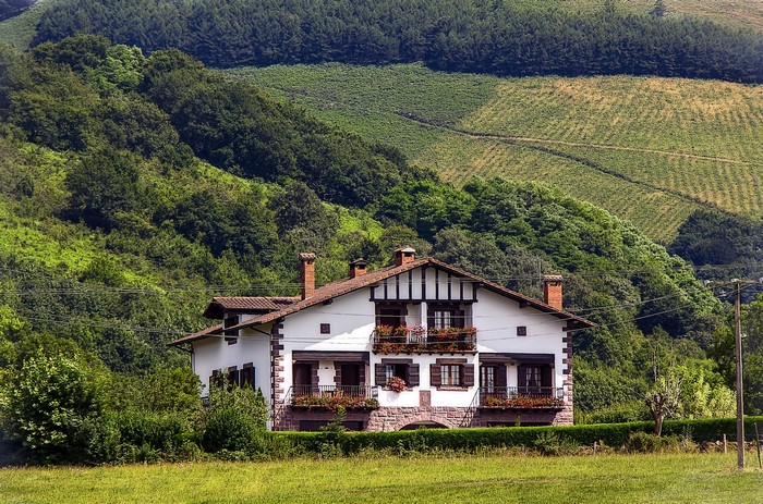Traditional house in Baztan, Navarre, Spain with green fields