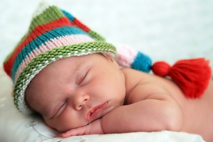 Baby sleeping in a colorful winter hat