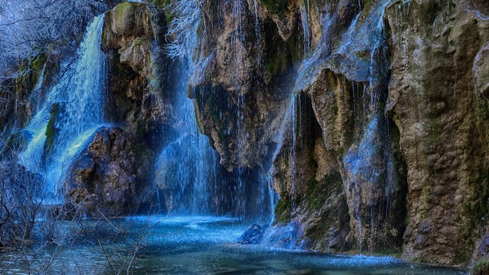 Waterfalls cascading over mossy rocks into a pool