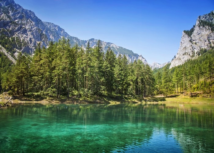 Clear turquoise lake surrounded by spruce forest and mountains