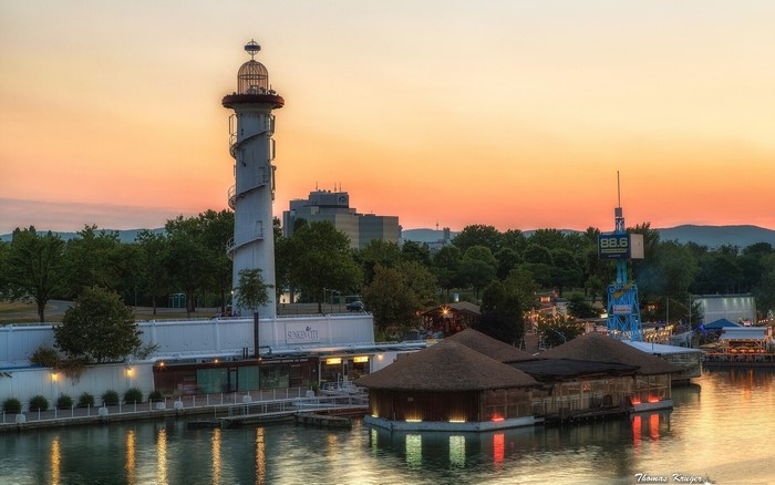 Lighthouse and waterfront buildings at sunset