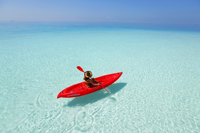 Woman kayaking in clear turquoise water