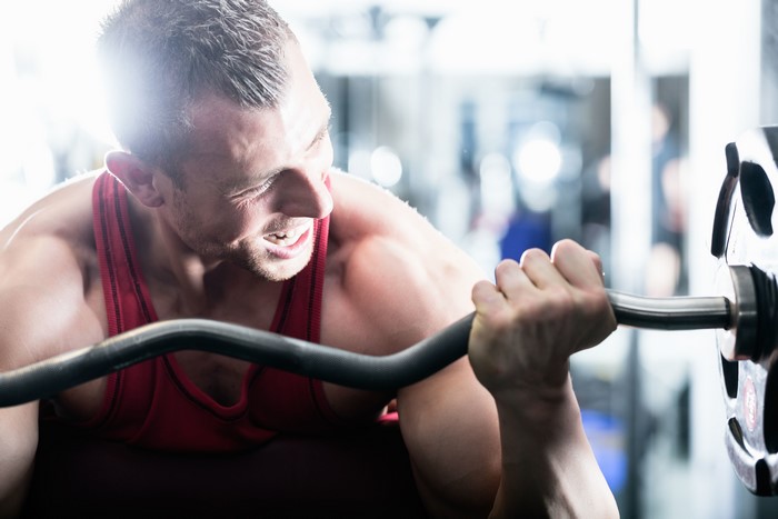 Man lifting barbell in gym