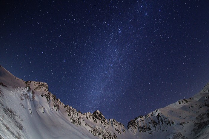 Snowy mountains under a starry night sky