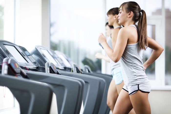 Women running on treadmills in a gym