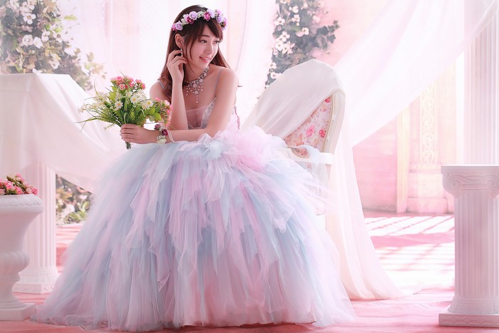 Bride in a pastel wedding dress holding flowers