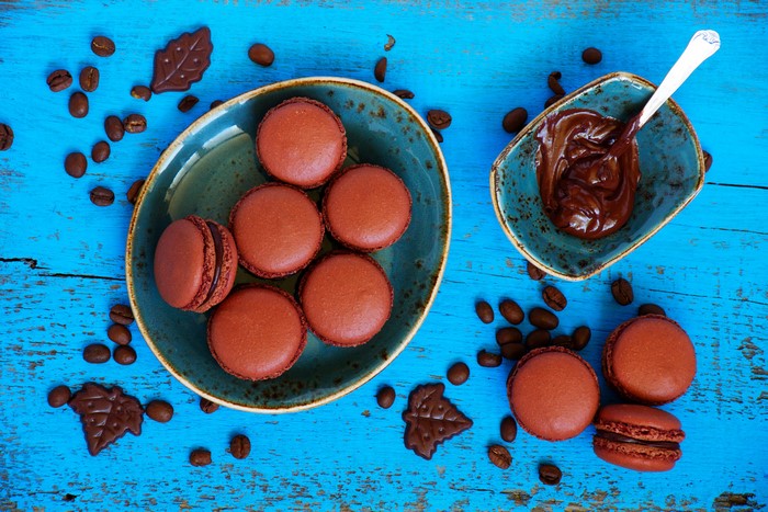 Chocolate Macarons and Coffee Beans on Blue Wood