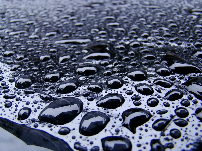 Closeup of water drops on a black surface