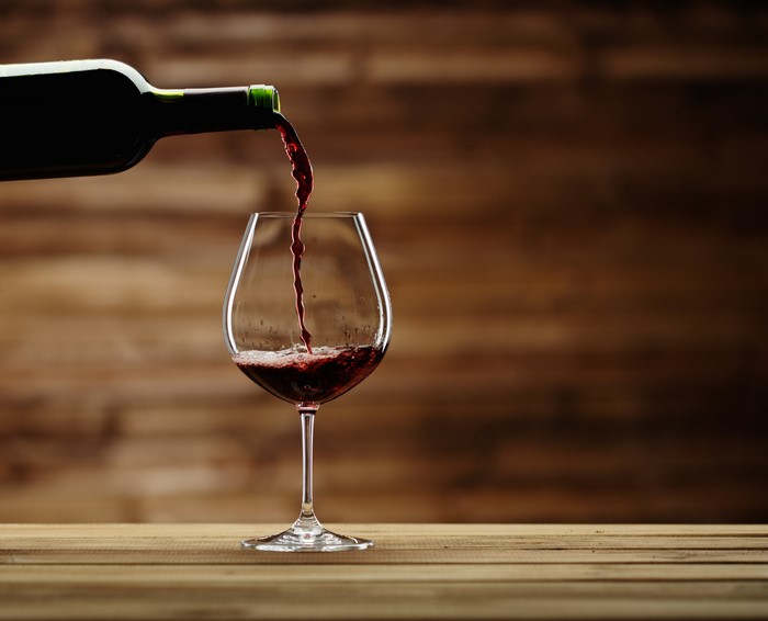 Red wine being poured from a bottle into a glass