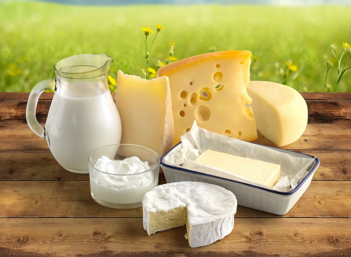 Dairy products on a wooden table with a green field background