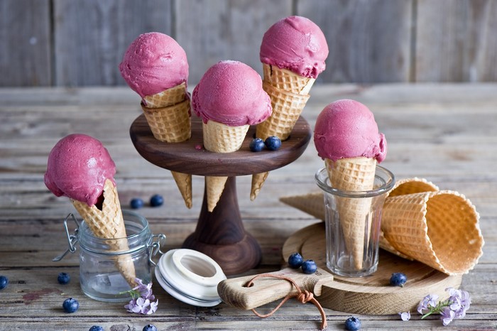 Blueberry ice cream cones on a wooden table