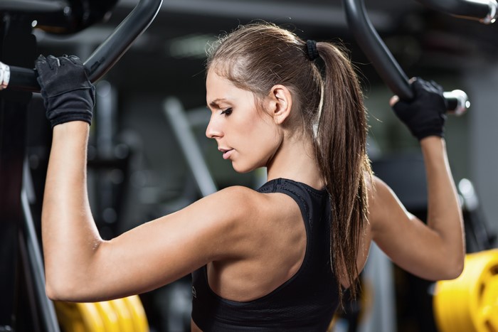 Woman working out on a lat pulldown machine