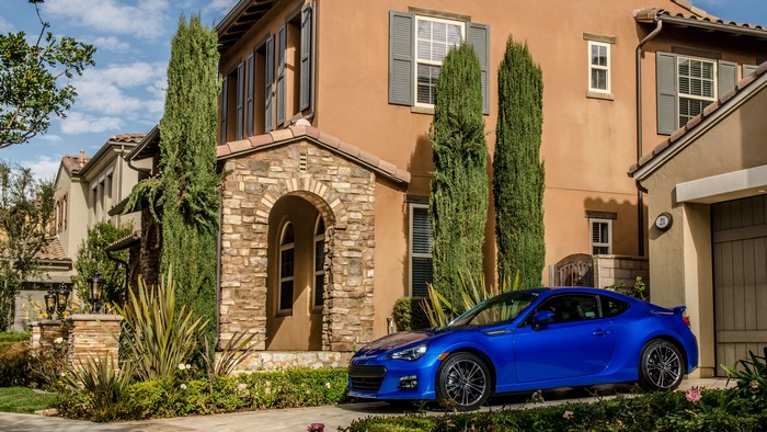 Blue Subaru BRZ parked in front of a house