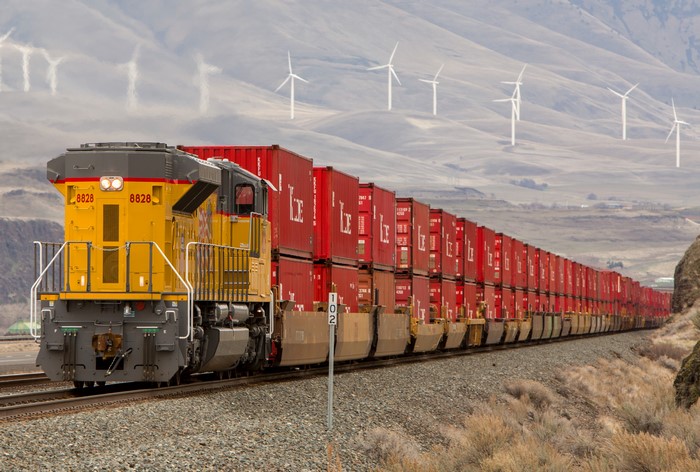 Union Pacific train with red shipping containers and wind turbines