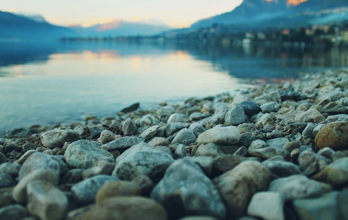 Stones on a lake shore with mountains in the background