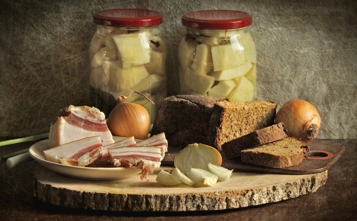 Still life with salo, bread, onions, and pickled vegetables