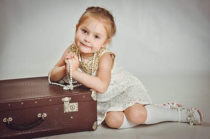 Girl with pearls and suitcase