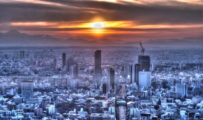 Tokyo cityscape at sunset with mountains in the background