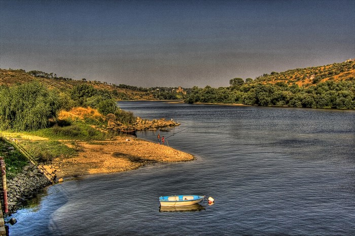 River landscape with boat and people fishing in Arrepiado Santarem, Portugal