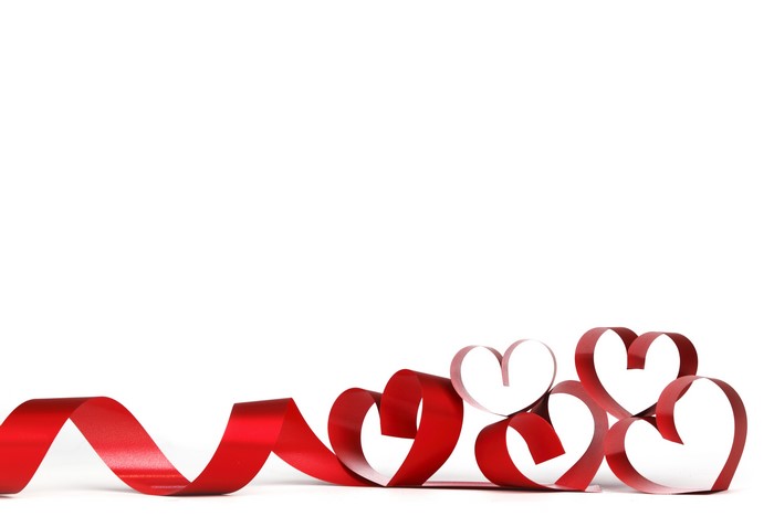 Red ribbon forming hearts on white background