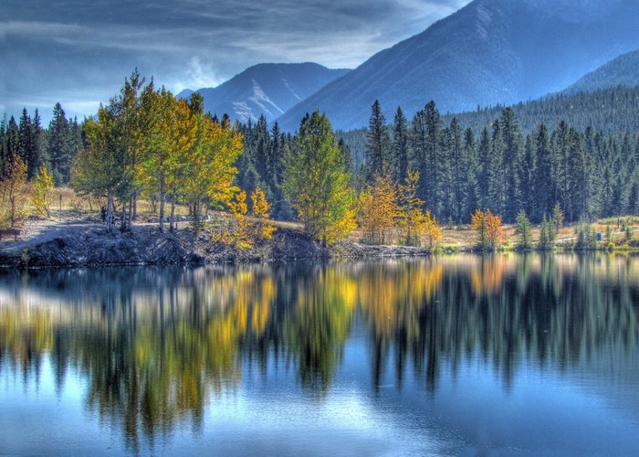 Autumn trees reflecting in a lake with mountains in the background