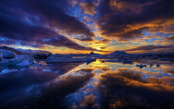 Icebergs floating in water during sunset