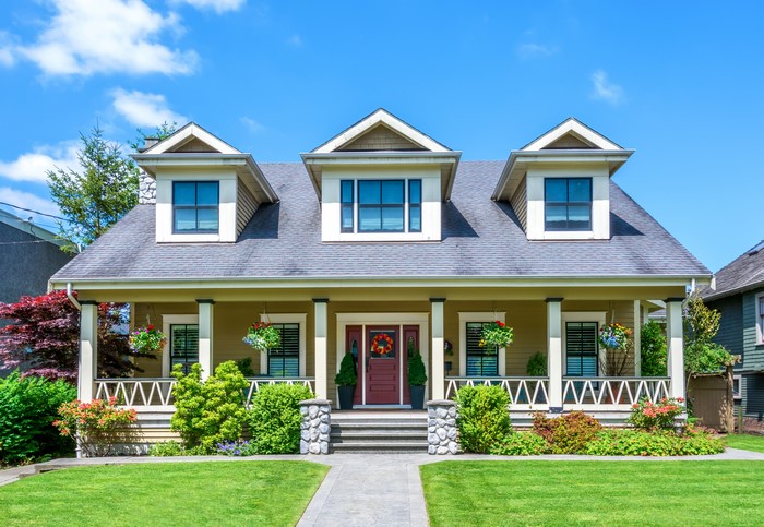 Yellow house with a porch and dormer windows
