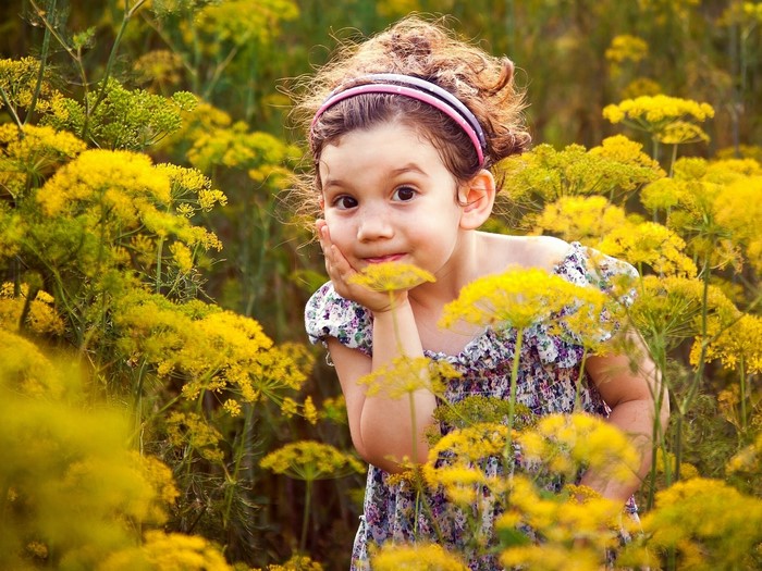 Young girl in a field of yellow flowers