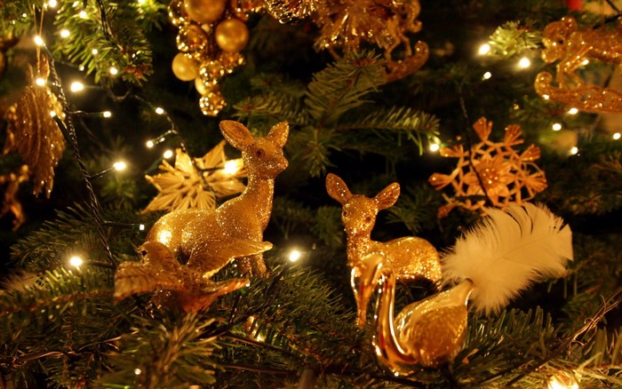 Golden deer ornaments on a Christmas tree with lights