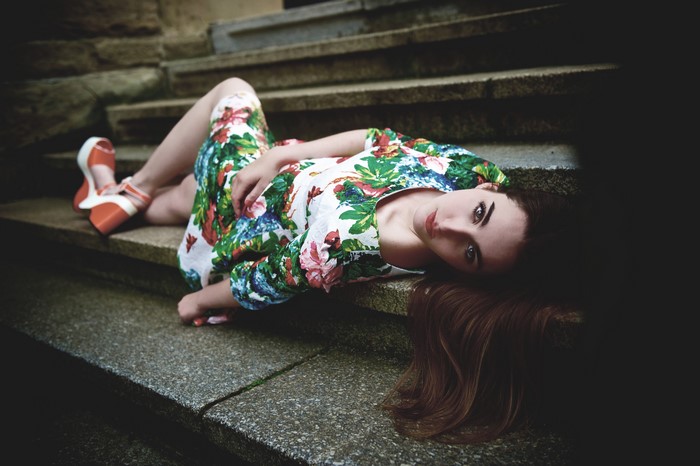 Woman in floral dress lying on stairs