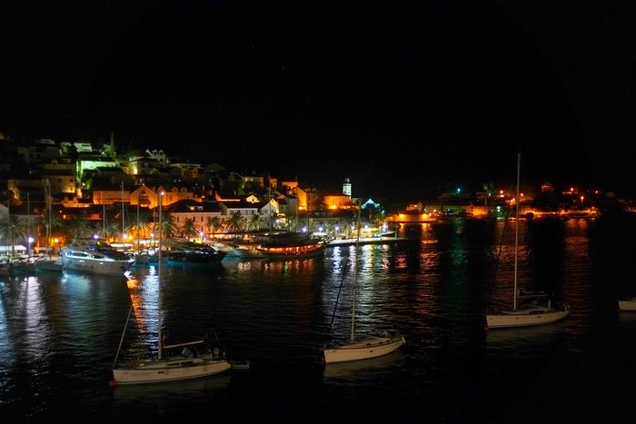 Night view of Hvar island marina with boats and illuminated houses