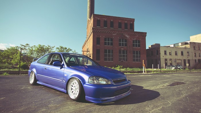Blue Honda Civic parked near brick buildings
