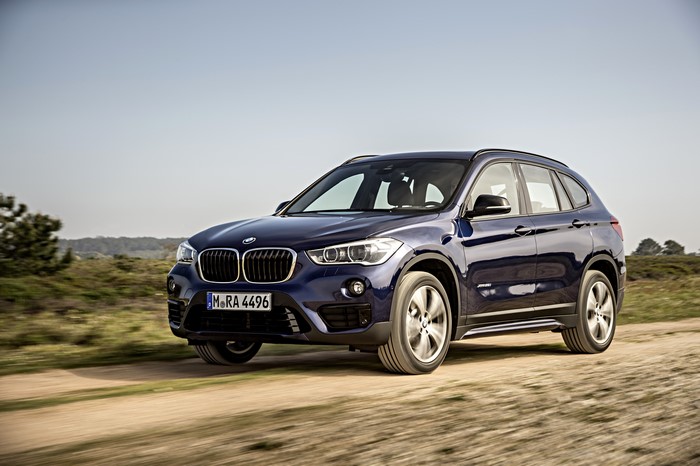 Blue BMW X1 F48 xDrive25i driving on a dirt road
