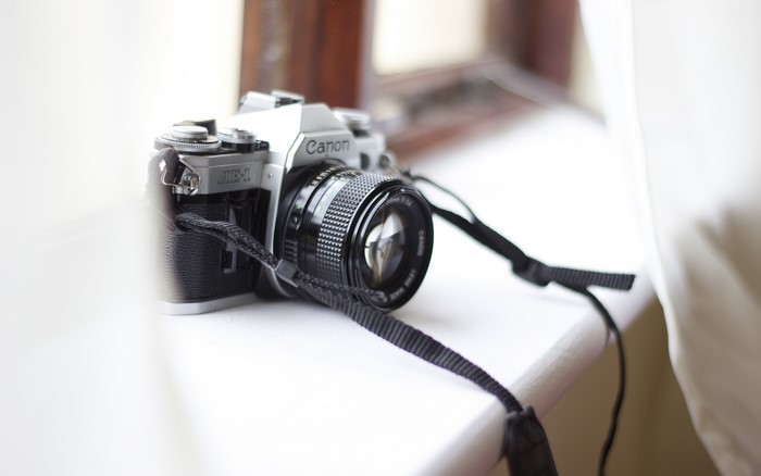 Canon AE-1 camera with lens and strap