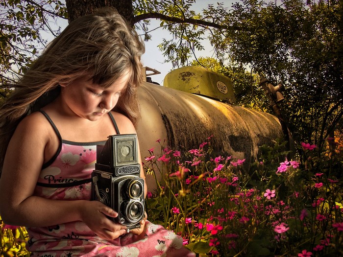 Girl with a vintage camera in a garden