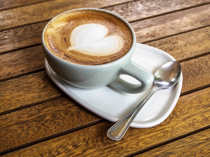 Cappuccino with heart art and spoon