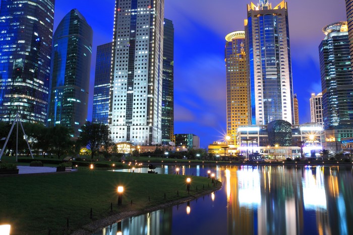 Skyscrapers reflecting in a pond at night