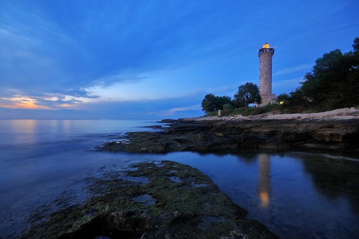 Lighthouse on the rocky coast of Istria, Croatia at dusk